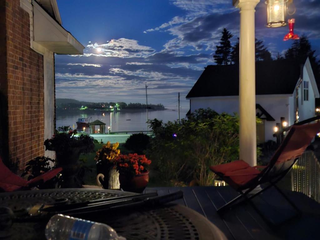 a porch with a view of the water at night at The View in Portuguese Cove