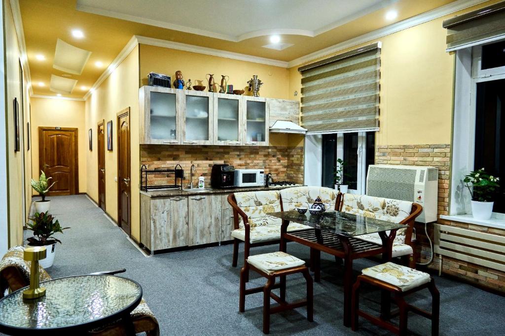 a kitchen and living room with a table and chairs at Dilbar Guest House in Samarkand