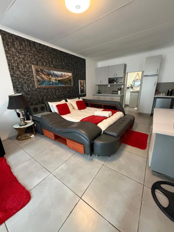 a bedroom with a large bed and a red rug at Rest Inn C Guesthouse - 10min from OR Tambo Airport in Boksburg