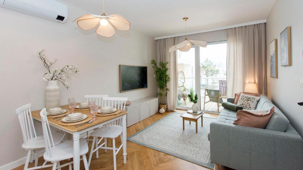 a living room with a table and a couch at Baltic Pine by Pino Resort in Gdańsk