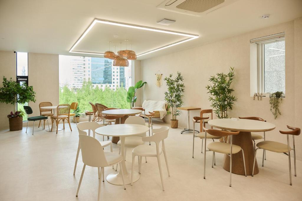 a restaurant with tables and chairs and plants at 쉼스테이 in Myŏnghag-yŏk