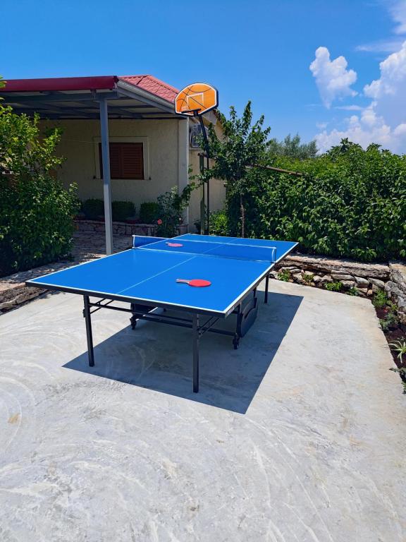 a blue ping pong table with a basketball hoop at Family PlayHouse - Villa Mitsi Sarande in Sarandë