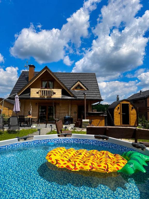 a pool with a bunch of inflatables in front of a house at Leśne Zacisze Radawa I in Radawa