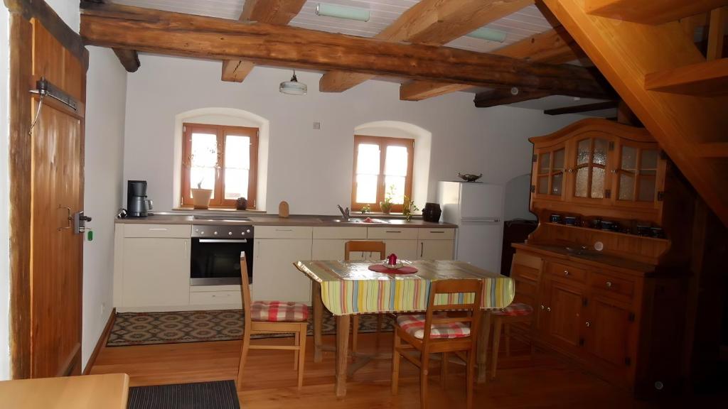a kitchen with a table and chairs in a room at Ferienwohnung Langhof in Schernfeld