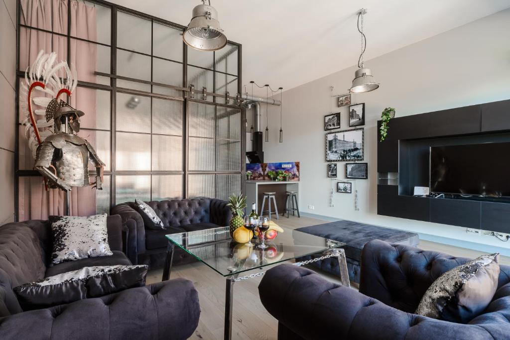 a living room with couches and a glass table at Lumina I Comfy Loft with Parking I View of the Lake in Łódź