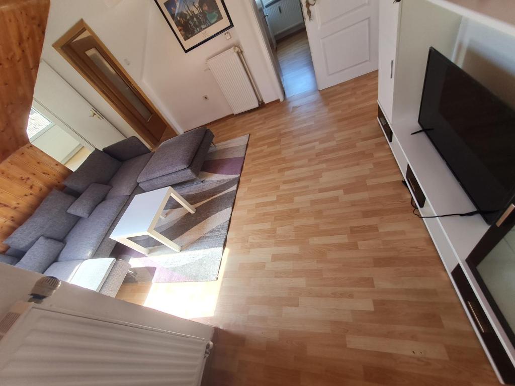 an overhead view of a living room with wood floors and a television at Vous êtes bienvenue in Ramstein-Miesenbach