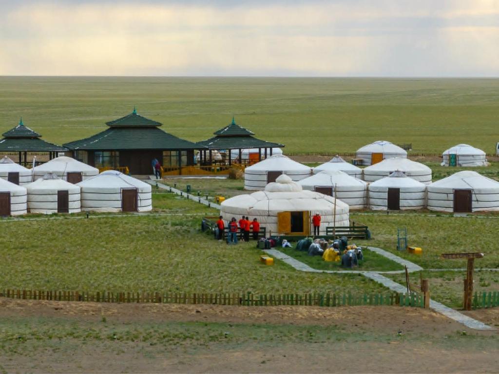 a group of domes in a field with people standing outside at Gobi Sun Lodge in Hushuu Hural
