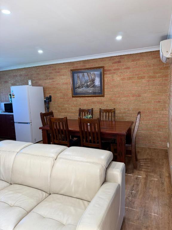 a living room with a white couch and a table at Corner unit in Geraldton in Geraldton