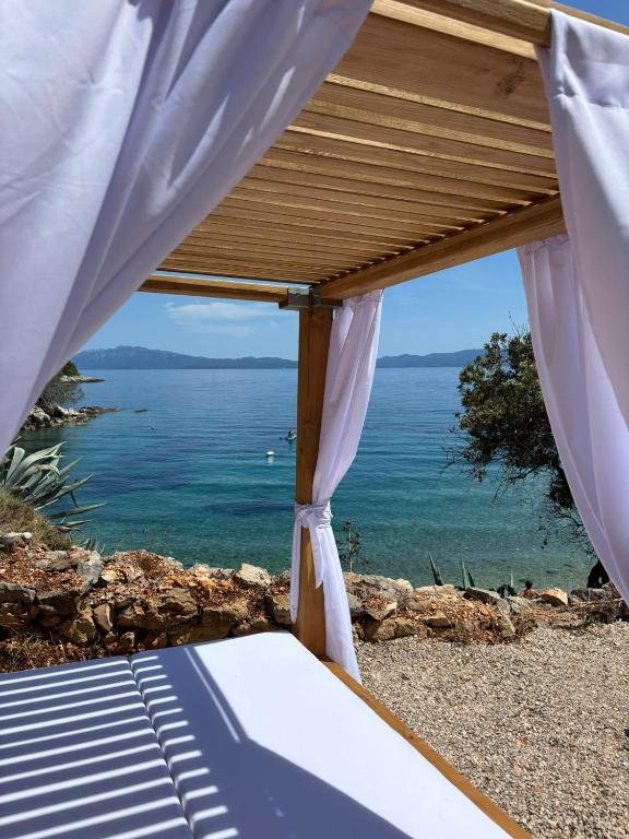 a bed with a view of the ocean at Robinson Medvidina Small room in Zastražišće