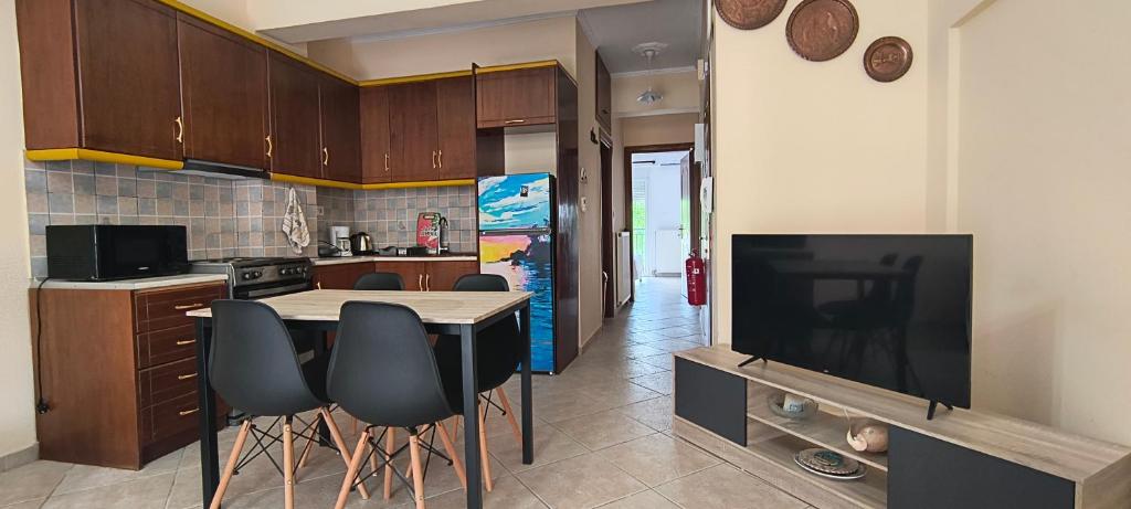 a kitchen with a table and chairs and a television at DESPOINA APARTMENT 2 Relax in Nea Michaniona