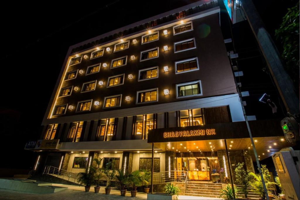 a tall building with lights on it at night at Hotel Bhagyalaxmi NX in Shirdi