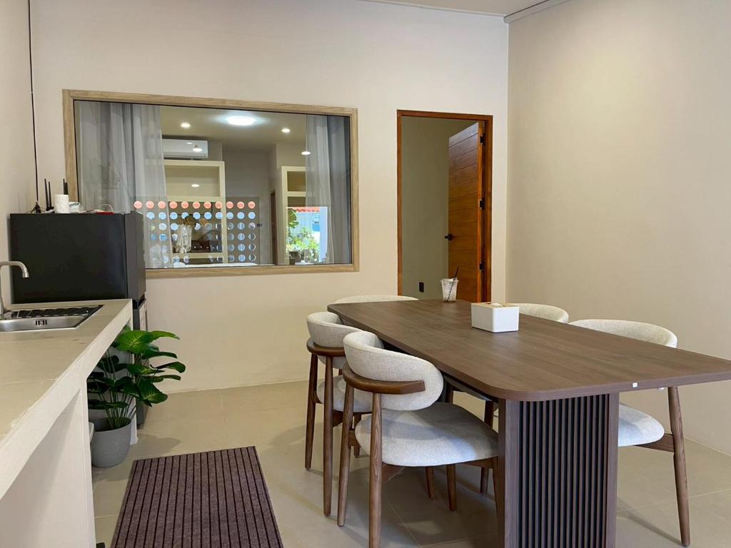 a kitchen with a wooden table and white chairs at Pani house in Ko Samed