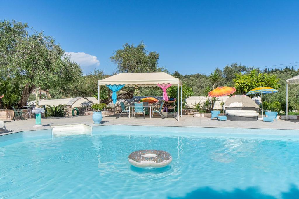 a swimming pool with a gazebo and a table and chairs at Paco's Resort Standard Studio 4 in Oziás