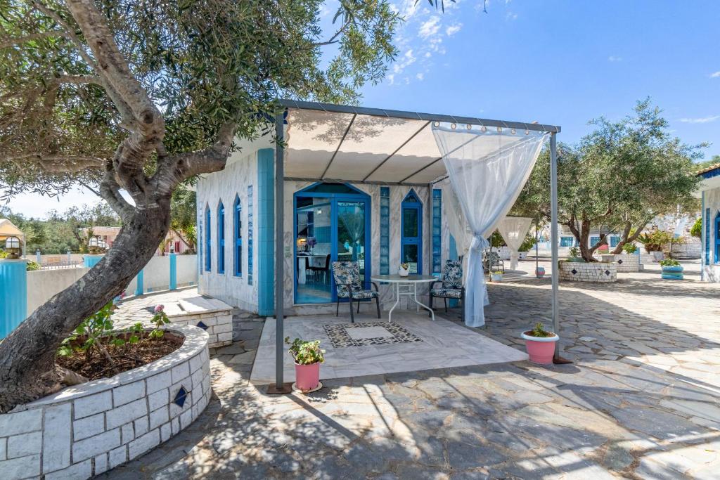 a blue and white house with a tree at Paco's Resort Superior Villa 7 in Oziás