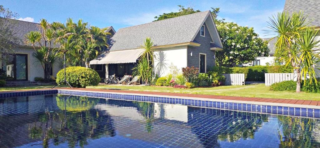 a house with a swimming pool in front of a house at 90 9 Pool Villa Chiang Mai in Ban Pa Ngae