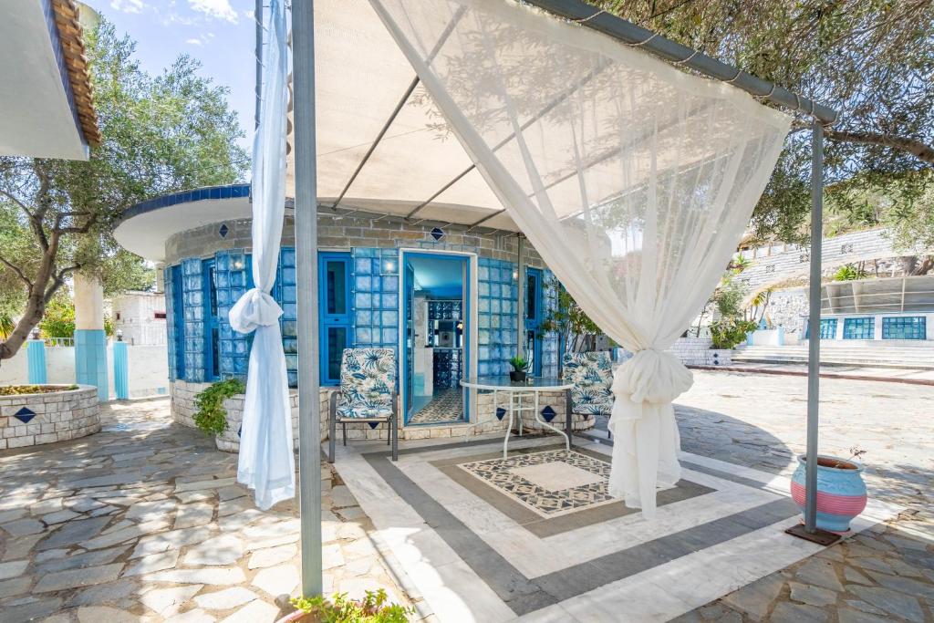 a blue and white house with a white canopy at Paco's Resort Superior Villa 6 in Oziás