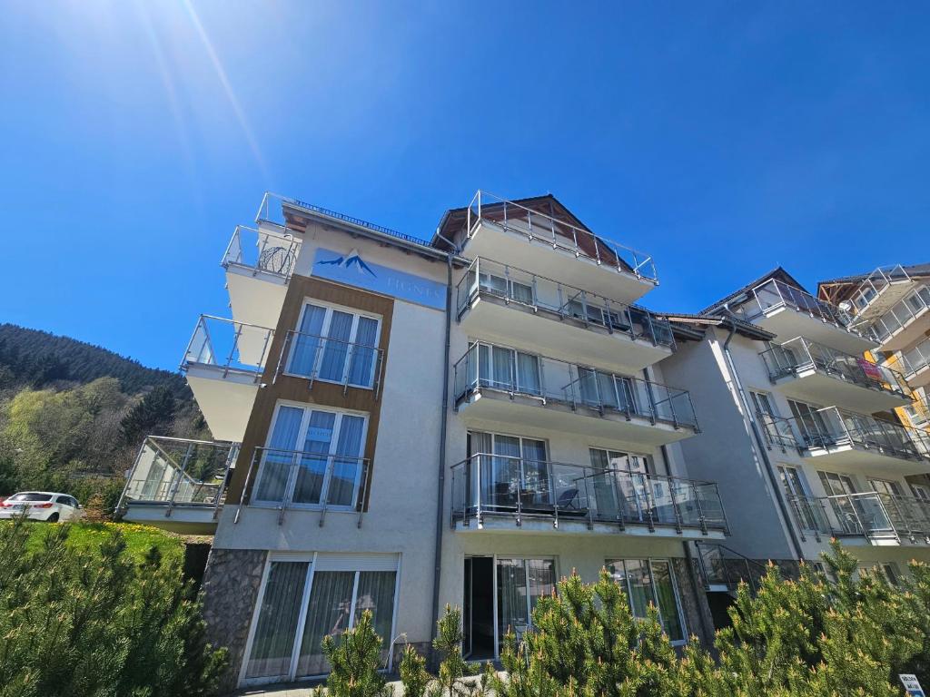 a white building with balconies and a blue sky at Apartament Czarna Góra TIGNES 4 Sienna in Sienna