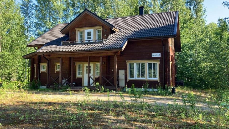 a wooden house with a gambrel roof at Villa SULKAVANRANTA in Sulkava