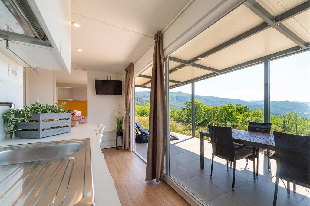 a kitchen and dining room with a table with a view at Vela Stina Mobile home in Roč