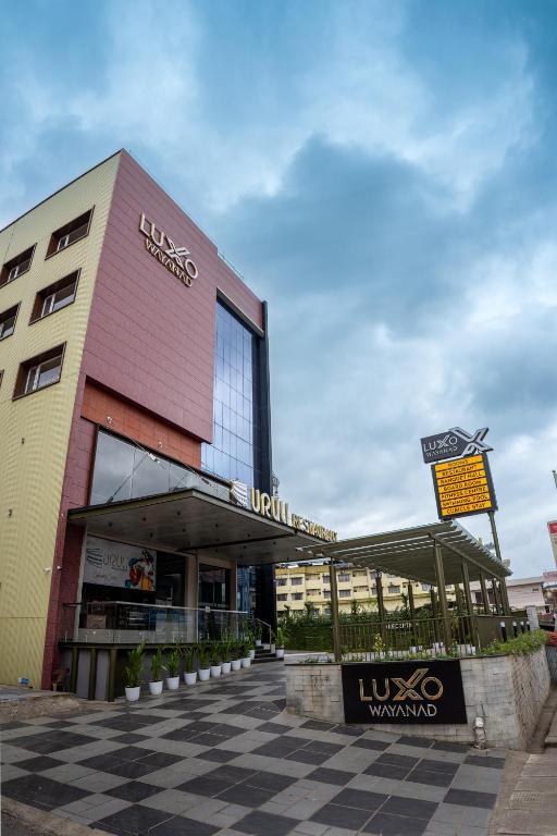 a building with a sign in front of it at Luxo Wayanad in Sultan Bathery
