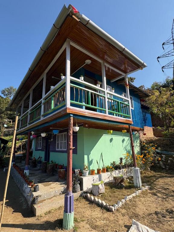 a house with a balcony on top of it at Karki Farm Stay in Bijanbāri Bāzār
