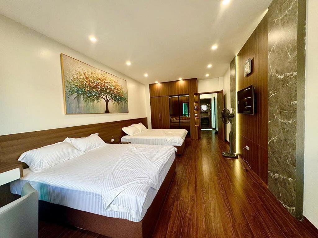 a bedroom with two beds and a painting on the wall at NBZ Homestay in Hanoi
