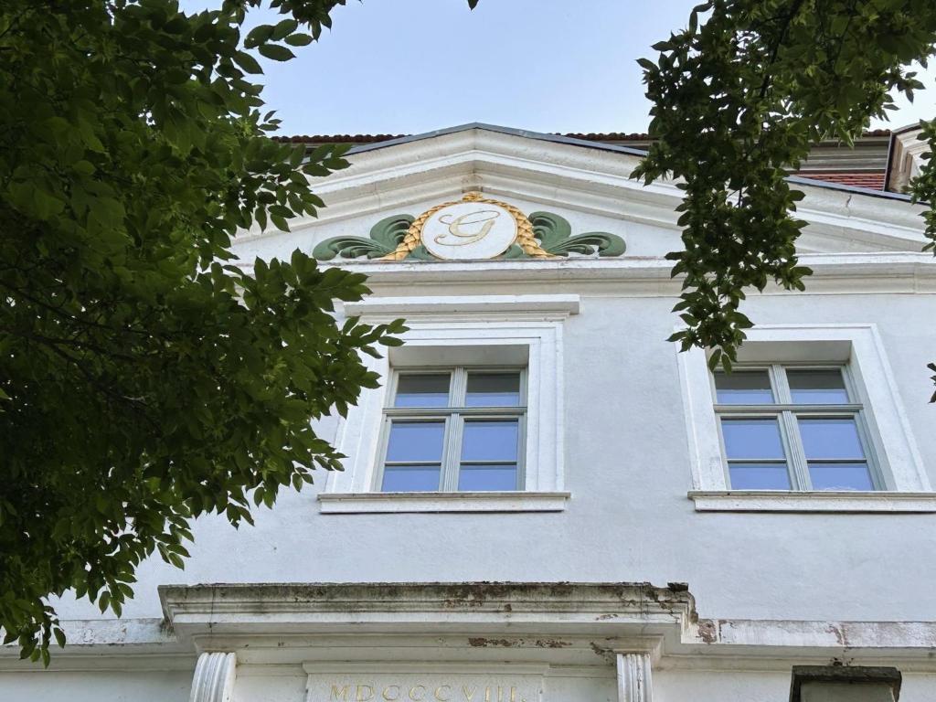 a white building with a clock on top of it at Rittergut Hohenfichte Herrenhaus in Leubsdorf