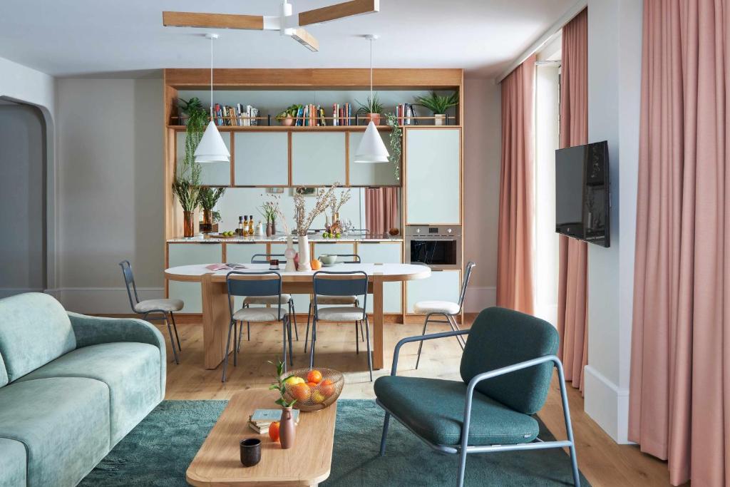 a living room with a couch and a table and chairs at Turing Locke Cambridge in Cambridge