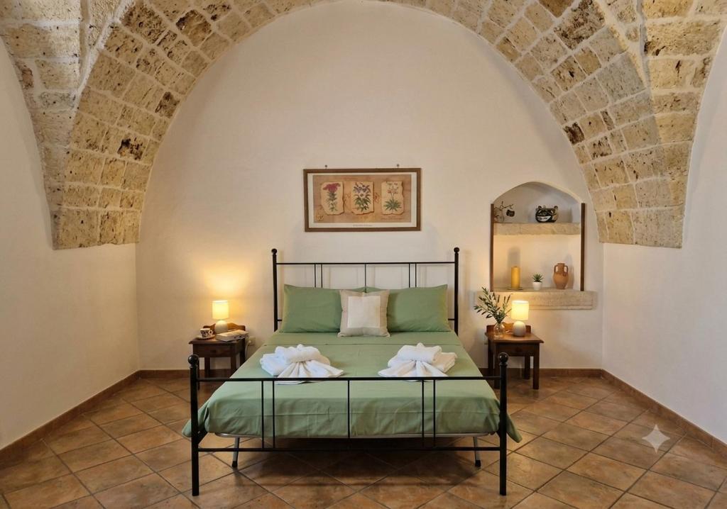 a bedroom with a bed with two night stands at La Corte di mezzo in Corigliano dʼOtranto