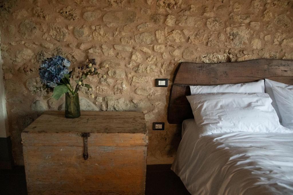 a bedroom with a bed and a vase of flowers on a table at Casale dei cappuccini in Scurcola Marsicana