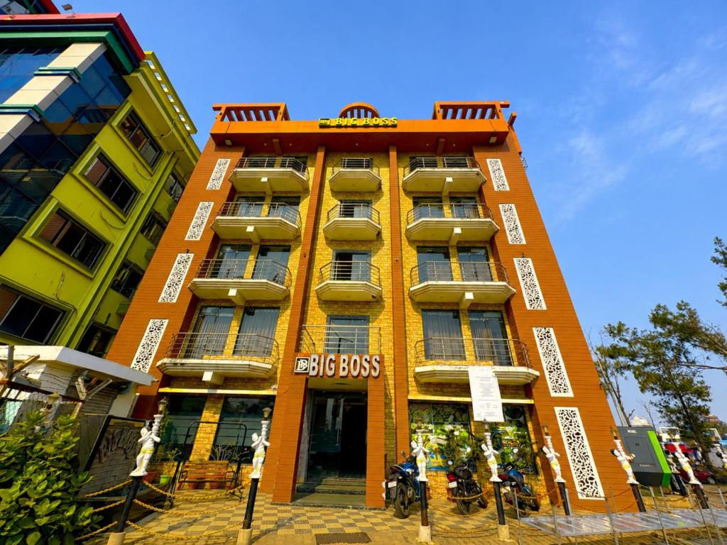 a tall orange building with motorcycles parked in front of it at Hotel Big Boss New Digha in Digha