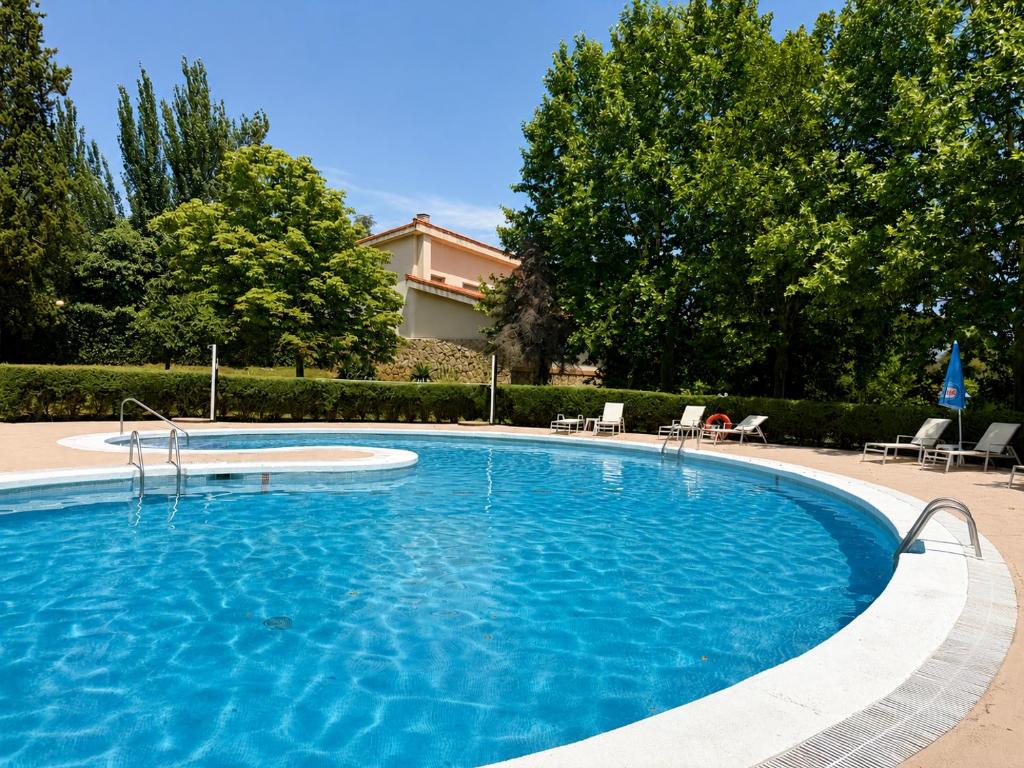 a large swimming pool with chairs in a yard at Gran Hotel Los Angeles in Getafe