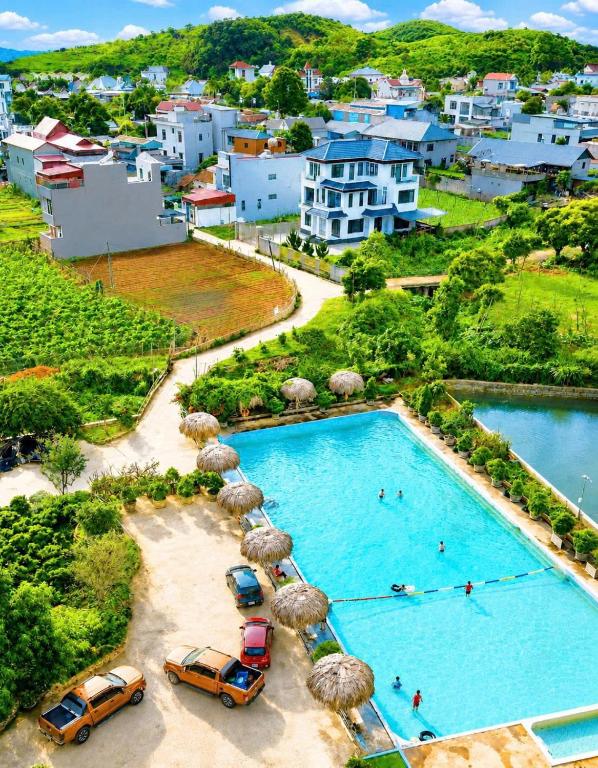 an aerial view of a pool with umbrellas and cars at Lộc Phát Hotel Mộc Châu in Làng Môn