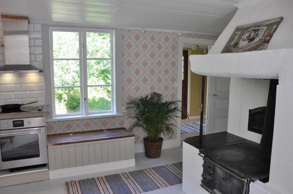a kitchen with a stove and a window at Grönhagen in Loftahammar
