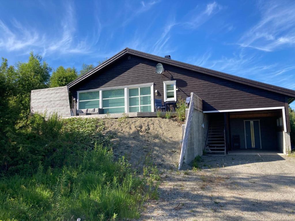 a house on top of a hill with a driveway at Flott hytte på Bjørgan in Grong