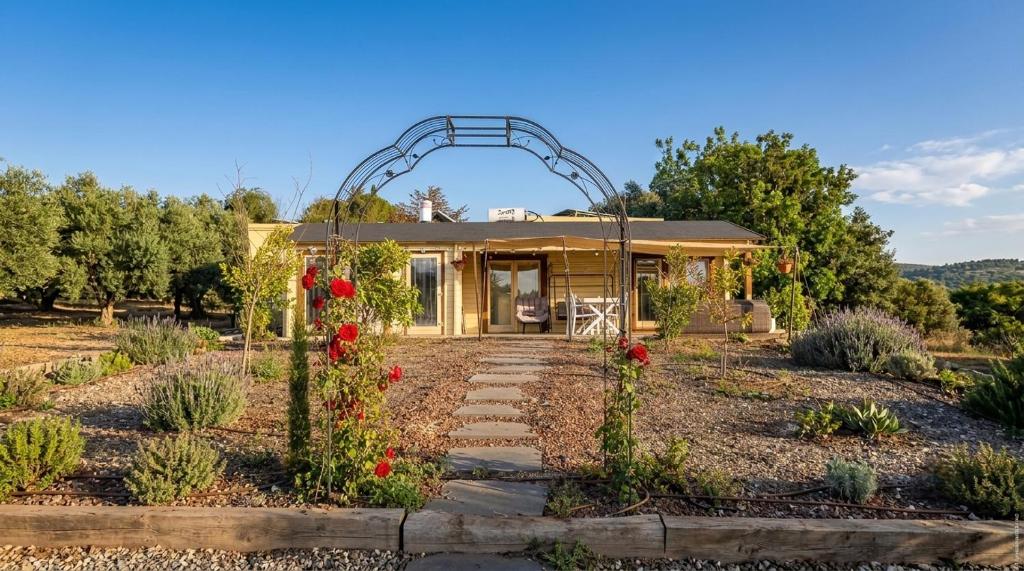 a house with an arch in a garden at The Heart Cabin בקתת הלב in Kidmat Tsvi