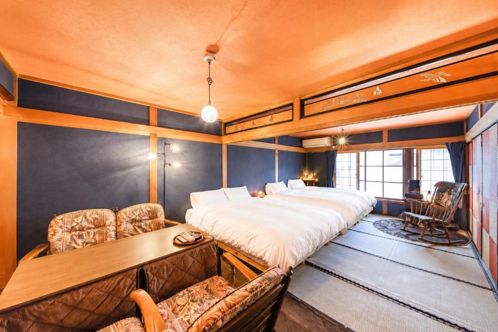 a bedroom with a large bed and a desk and chairs at とれるの【TORERUNO】 in Takayama