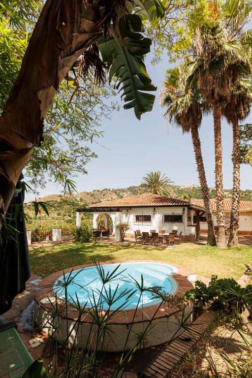 a backyard with a swimming pool and a house at Cortijo Santa Cruz in Almuñécar