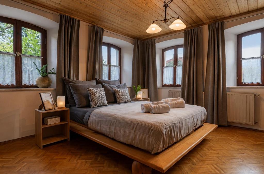 a bedroom with a large bed with windows at Alpaka Erlebnis-Ruhige Land-Auszeit in Dinkelsbühl