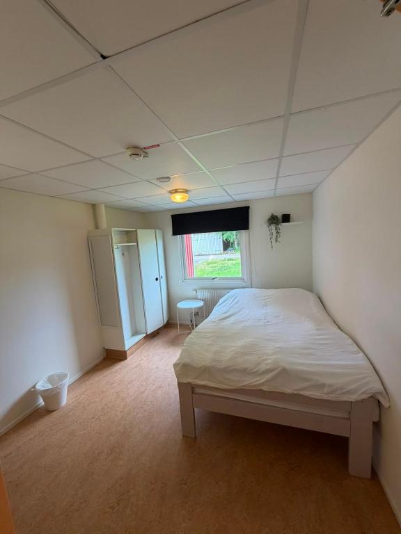 a bedroom with a white bed and a window at Örkelljunga Hostel in Orkelljunga