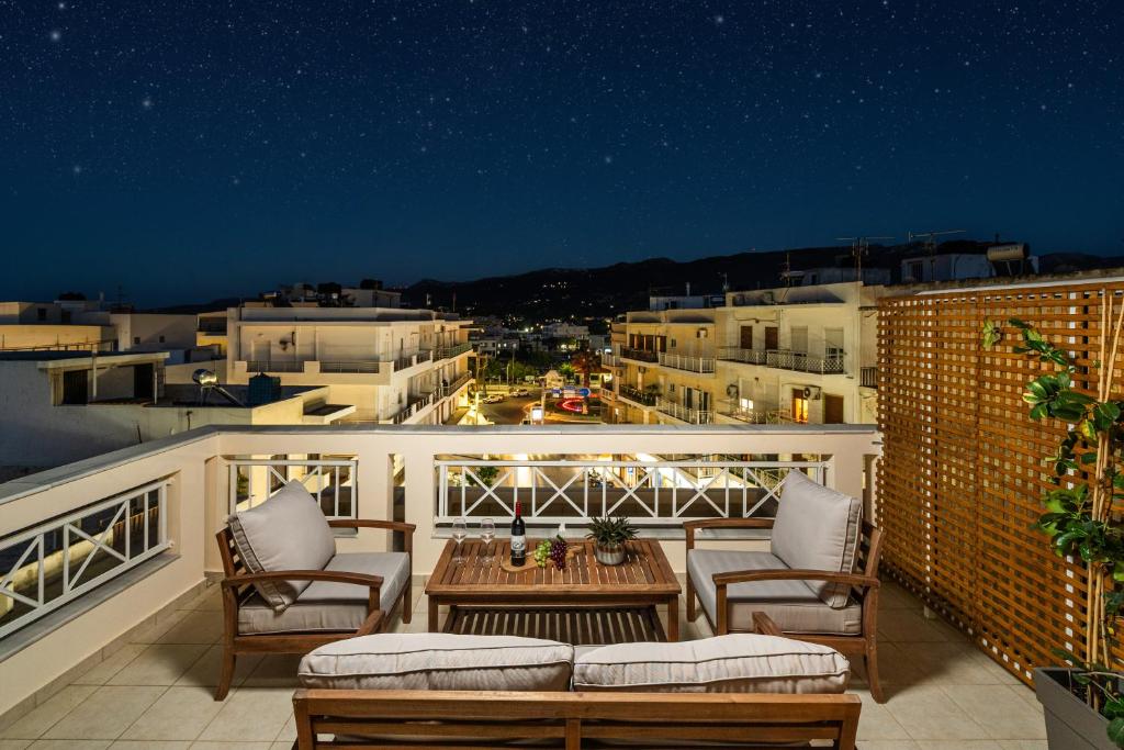 a balcony with chairs and a table on a building at Fontana La Vista in Sitia