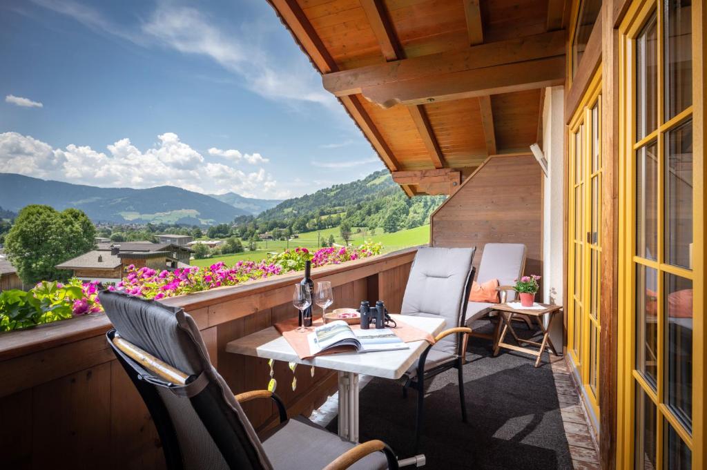a balcony with a table and chairs and flowers at Appartement Irmgard in Brixen im Thale