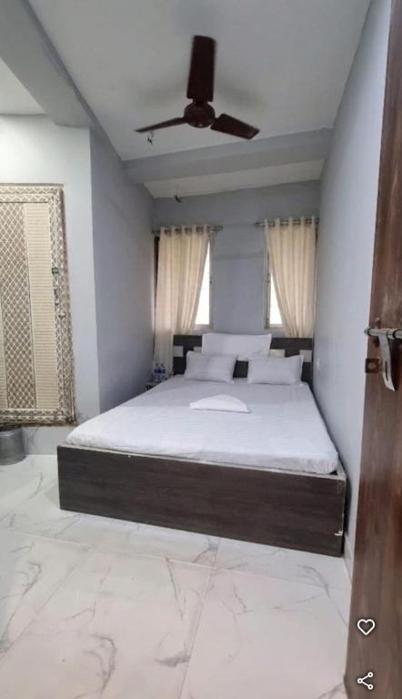 a bedroom with a bed with a ceiling fan at All sana guest house in Kolkata