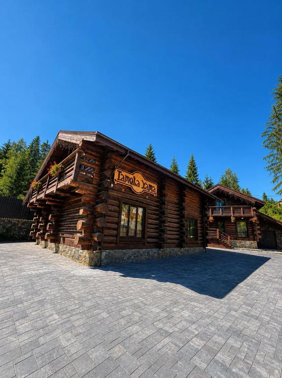 a log cabin with a sign on the front of it at Tatova Hata in Yablunytsya