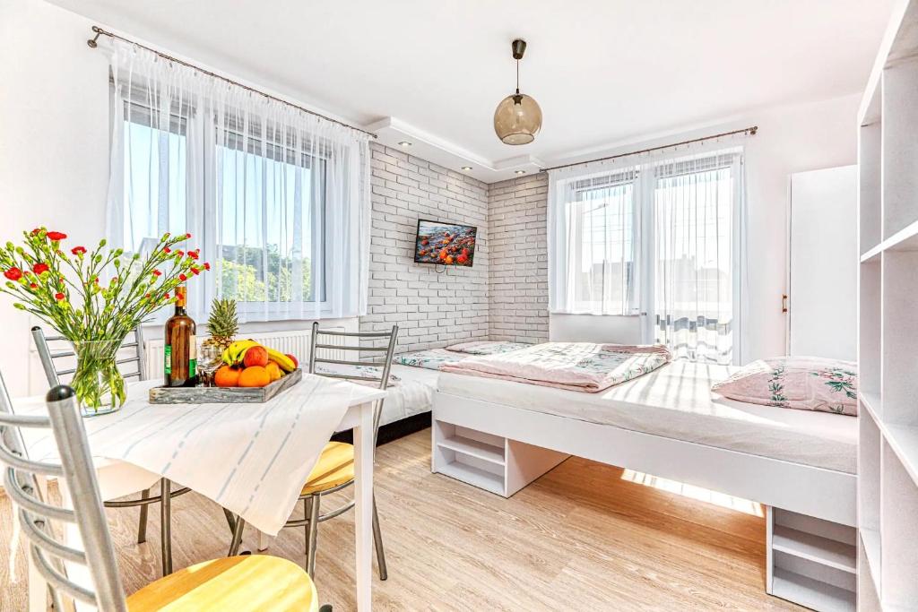 a room with two beds and a table and chairs at WillaSimi in Władysławowo