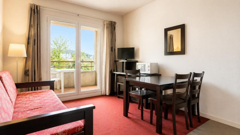 a hotel room with a dining room table and a desk at Virginia N108 - 2P4 in Grasse