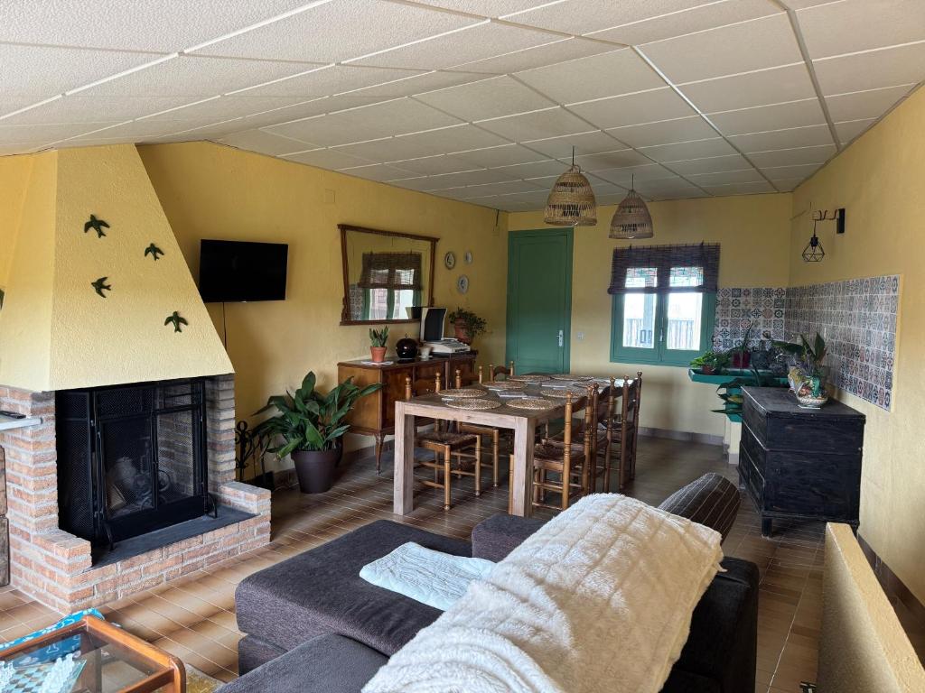 a living room with a fireplace and a table at Oreneta in Fatarella
