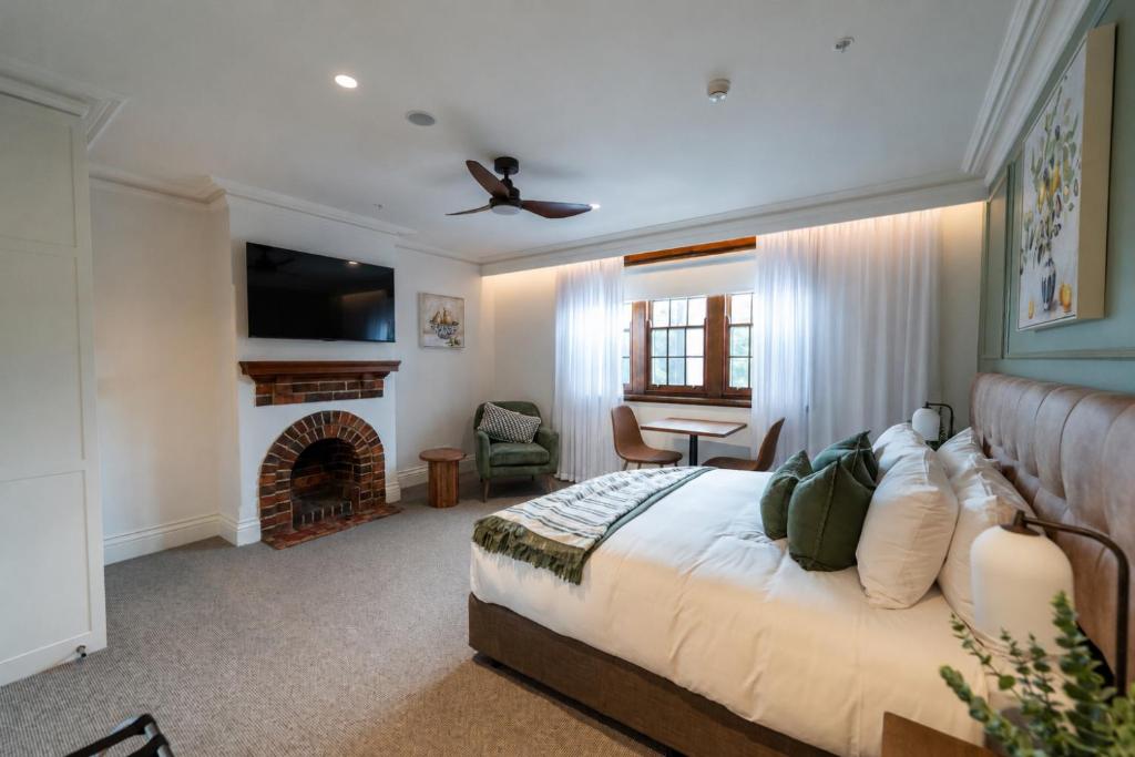 a bedroom with a large bed and a fireplace at Camden Hotel Suites in Camden
