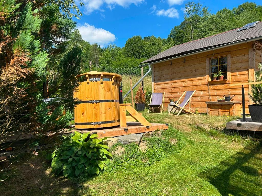 a wooden cabin with a bench in the yard at Medový domek Nový Hrozenkov in Nový Hrozenkov