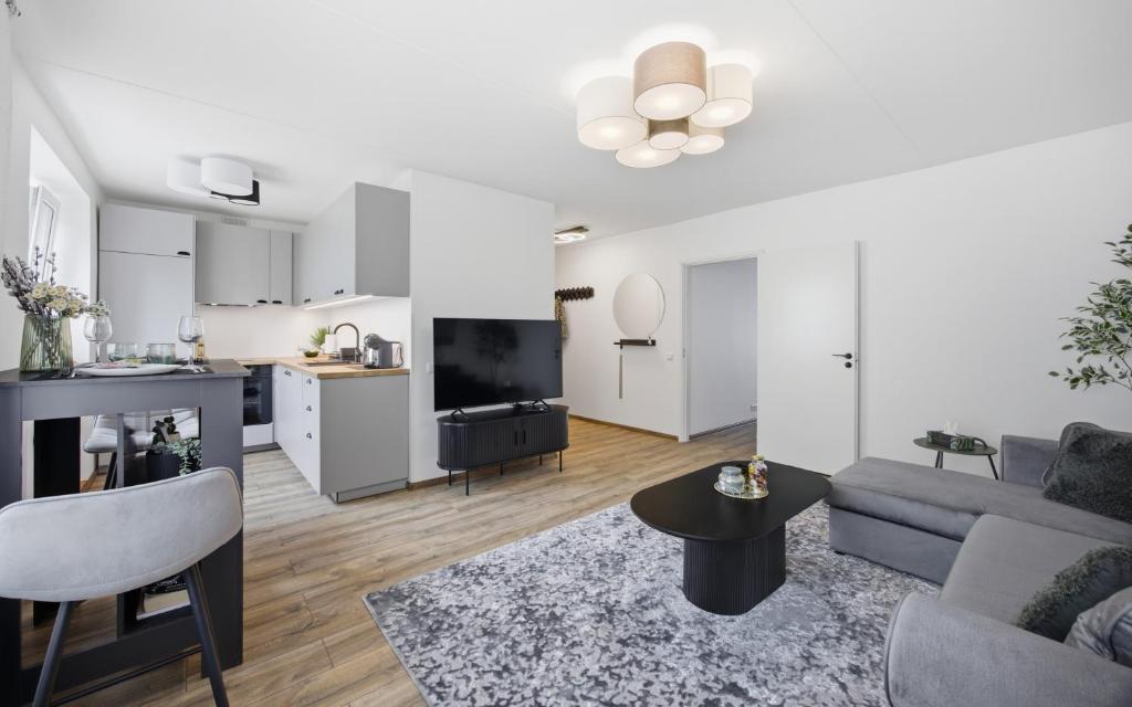a living room with a couch and a kitchen at Hygge House Elva in Elva